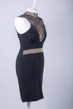 Bir yapılandırılabilir bir siyah ve altın dantel elbise giymiş manken