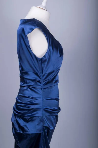 A Tailors Mannequin dressed in a Blue Satin Dress