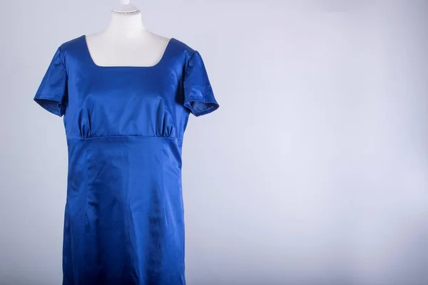 A Tailors Mannequin dressed in a Blue Satin Dress