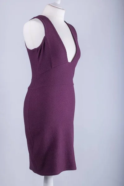 A Tailors Mannequin dressed in a Purple Dress