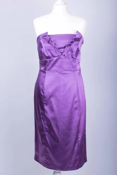 A Tailors Mannequin dressed in a Purple Satin Dress