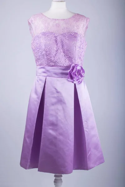 A Tailors Mannequin dressed in a Purple Dress