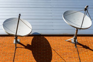 İki çanak antenler tuğla duvar