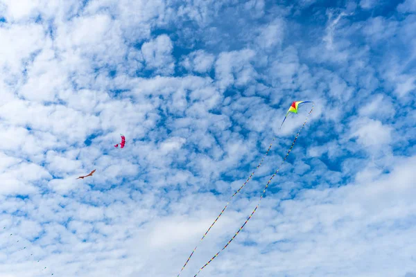 Sárkányokat repül az égen a felhők között. Kite Fesztivál — Stock Fotó