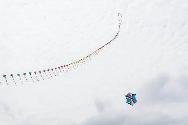 Vliegers vliegen in de lucht onder de wolken. Kite Festival — Stockfoto