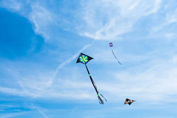 Latające na niebie wśród chmur. Festiwal kitesurfingu — Zdjęcie stockowe