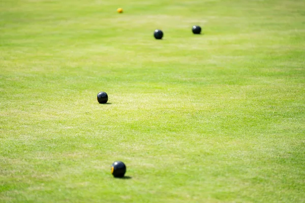 Bowls or lawn bowls is a sport in which the objective is to roll biased balls so that they stop close to a smaller ball called a jack or kitty