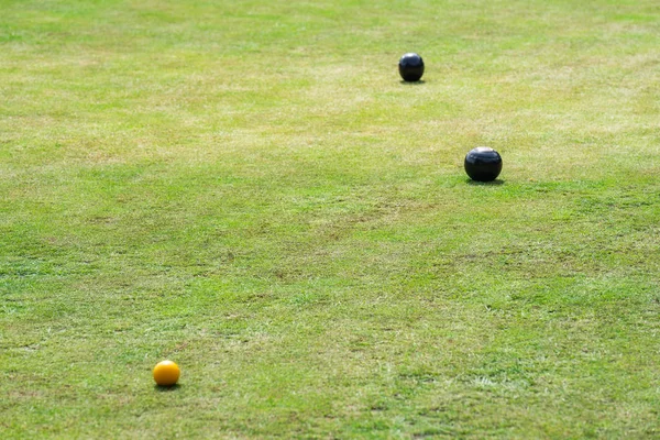 Bowls or lawn bowls is a sport in which the objective is to roll biased balls so that they stop close to a smaller ball called a jack or kitty