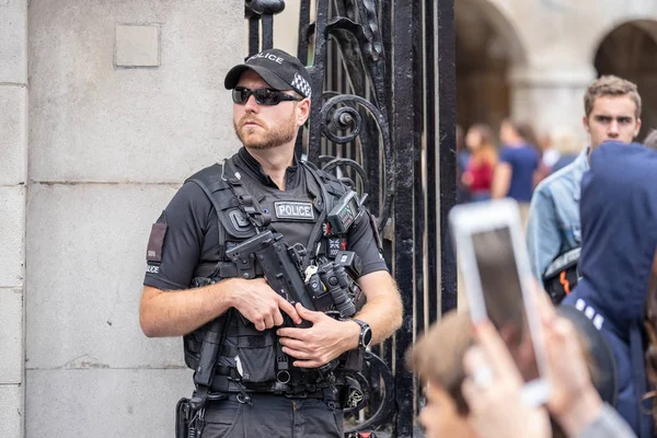 Londen, UK, juli, 2019. Een politieagent met een machinegeweer die steek en kogel bestendig vest draagt — Stockfoto