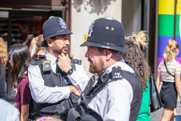 Londres, Reino Unido, julio de 2019. Dos policías británicos patrullando las calles de Inglaterra con chalecos antipuñaladas. Oxford Street. Enfoque seleccionado — Foto de Stock