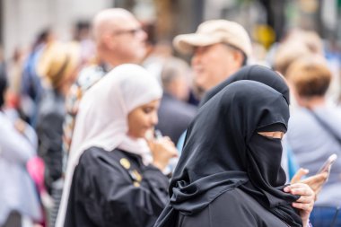 Londra, Ingiltere, Temmuz, 2019. Londra 'da bir Müslüman kadın bir niqab giyen, cep telefonu kullanarak alışveriş yaparken. Oxford Caddesi