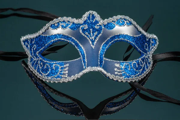 Коломбина, синяя карнавальная или маскарадная маска на черном зеркальном фоне — стоковое фото