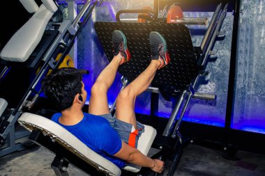 Asyalı erkek egzersiz bacak basın makine yaşam fitness Health.Metaphor spor için birini ve kilo kas vücut geliştirmeci eğitmen esneme görüntü.