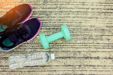Şişe ve yeşil renk dumbbell yere ile spor ayakkabı