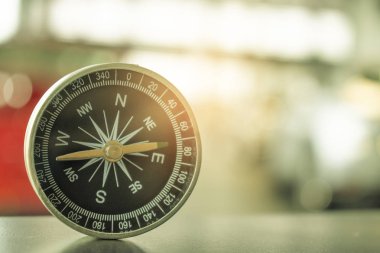 Ağaç dağında pusula ve denizin bulanık arka planında duruyor. Duvar kağıdı, arkaplan yolculuğu veya navigatör resmi kullanılarak.