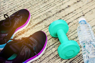 Şişe ve yeşil renk dumbbell yere o ile spor ayakkabı