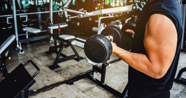 Halter ağırlıklı Asyalı vücut geliştirici yakışıklı sporcu