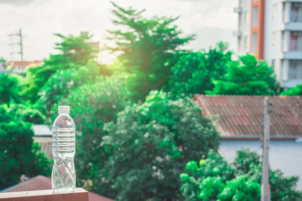 Пляшкова Вода Зроблена Пластику Небі Розмитим Будинком Деревом Боке — стокове фото