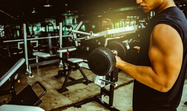 Dambıl ağırlıklı Asyalı vücut geliştirici yakışıklı atletizm egzersizleri yapıyor. Metafor ve egzersiz konsepti. Sağlık yaşam tarzı kas vücuduna dikkat et.