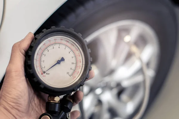 Hombre asiático inspección del coche Medida cantidad Neumáticos de goma inflados — Foto de Stock