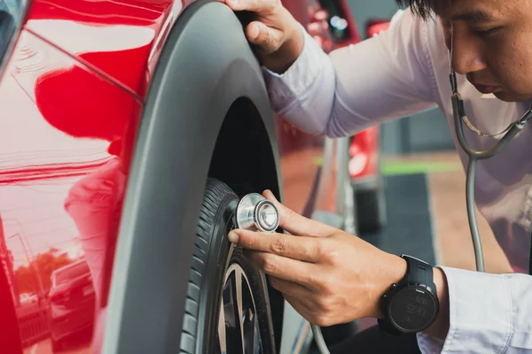 Asian man holding stethoscope car inspection Rubber tires car.Cl — Stock Photo, Image