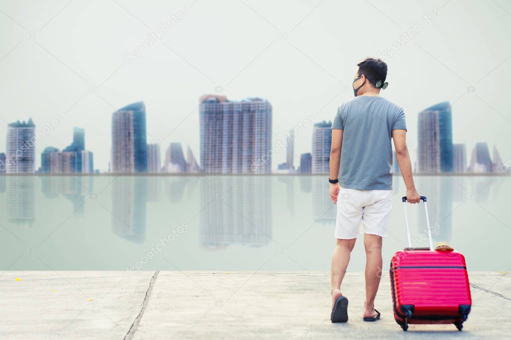 Man asian tourist Look at city and the sea Before sunset.for activity lifestyle outdoors freedom or travel tourism inspiration backpacker tourist to covid 19