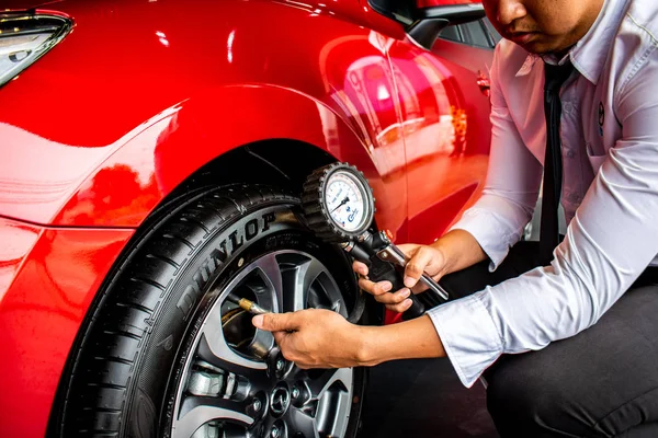 Asian man car inspection Measure quantity Inflated Rubber tires — Stock Photo, Image