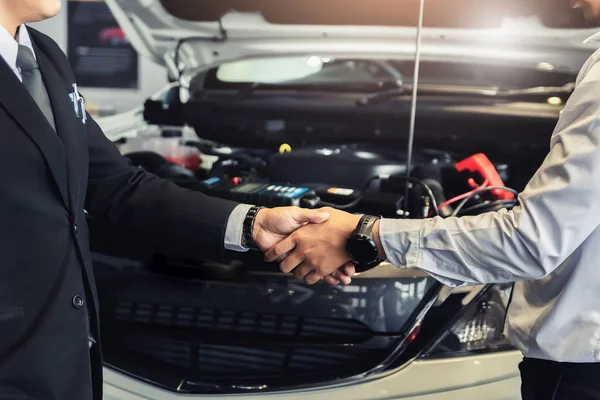 Dos hombres asiáticos tendiendo la mano o estrechando la mano al mecánico con el jefe. — Foto de Stock