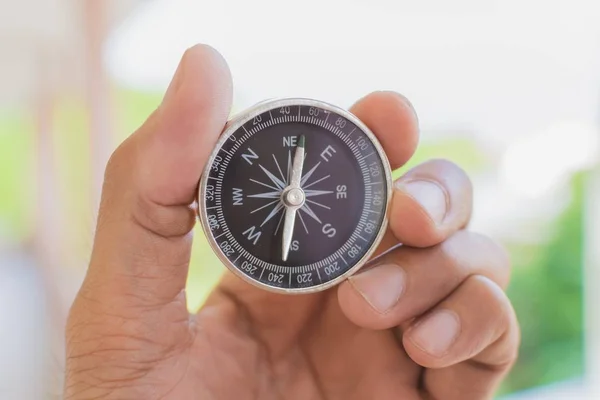 Een man met een kompas op een wazige achtergrond. voor de levensduur van de activiteit — Stockfoto
