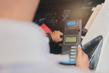 Seri için Batarya Test Voltmetresi 'ni tutan adam denetimi.
