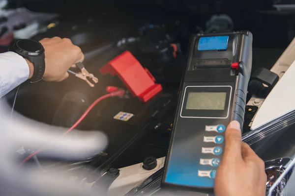 Inspección del hombre que sostiene el probador de capacidad de la batería Voltmeter.for ser —  Fotos de Stock