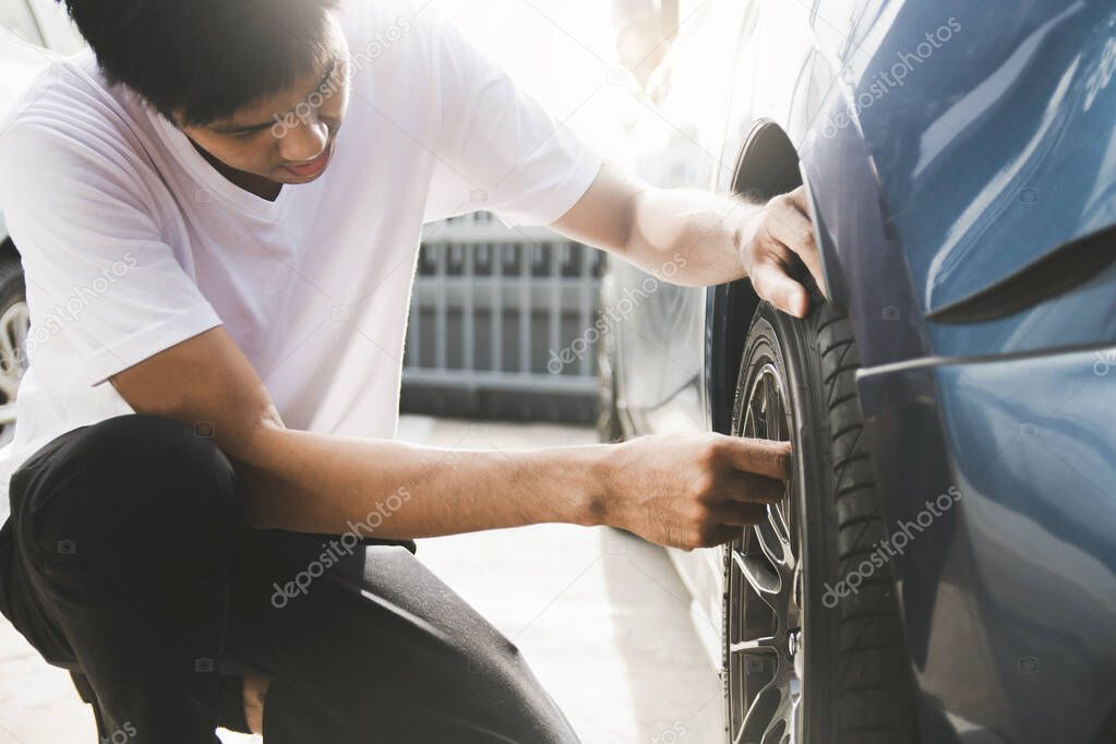 Asian man car inspection Measure quantity Inflated Rubber tires 