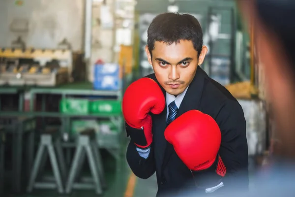 Asiático hombre de negocios desgaste traje perforando rojo boxeo guantes en indust —  Fotos de Stock