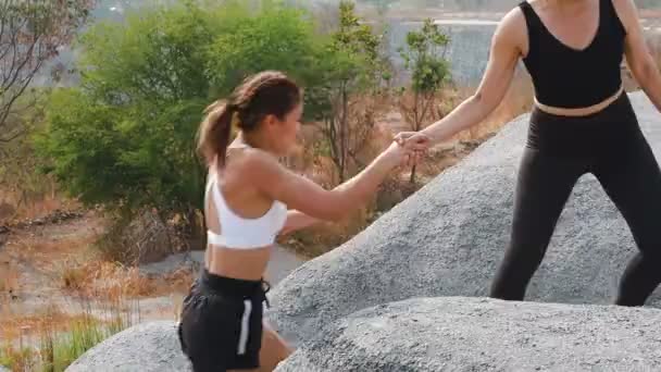Siyah Spor Kıyafetli Kadın Arkadaşının Tepeye Çıkmasına Yardım Ediyor — Stok video