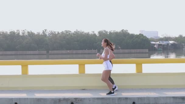 Filmagem Duas Fêmeas Asiáticas Preto Branco Sportswear Jogging Ponte Juntos — Vídeo de Stock