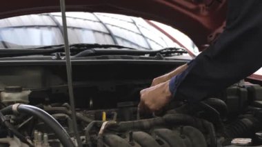 Asyalı bir adamın bir arabanın motorunu kontrol ederken görüntüsü. Araba tamir istasyonu ya da teknisyen uzmanı konsepti