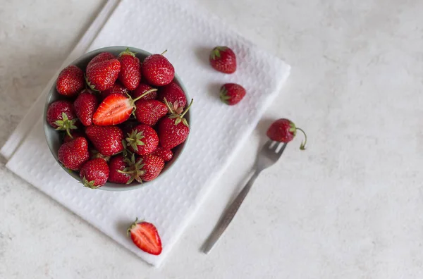 직물이 세라믹 그릇에 맛있고 딸기입니다 근처에 디저트 포크와 열매가 나막신 로열티 프리 스톡 사진