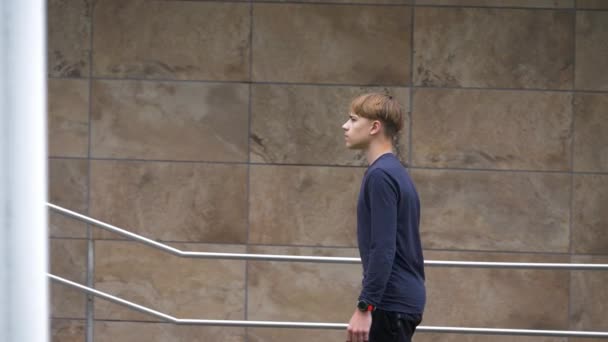 Bewegende Ansicht eines Teenagers beim Treppensteigen. Junge geht konzentriert geradeaus. — Stockvideo