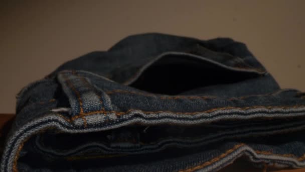 Sondens lins bild av jeans ficka. Kamerarörelse från utsidan till insidan av fickan, mynt i den. Närbild bild bild av denimmaterial. — Stockvideo