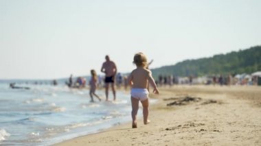 Aile zamanı. Anne kızıyla oynuyor. Genç ve güzel bir kadın küçük kızının peşinden koşar, onu saklar ve ellerini tutarak dönmeye başlar. Küçük kız gülümsüyor ve gülüyor. Tutma.