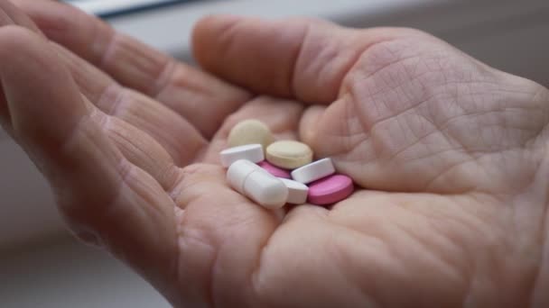 Close-up shot van gerimpelde oude vrouwen hand met verschillende medicijnen tabletten. Hoeveelheid pillen die senior overdag moet drinken. — Stockvideo