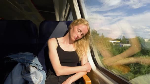 Modelo de aspecto escandinavo duerme en el tren. Hermosa mujer sueña mientras duerme después del trabajo. Viaje nocturno soleado. — Vídeos de Stock