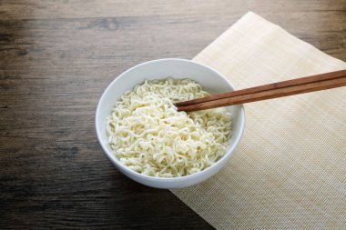 Kase, yemek çubukları ve ahşap tabl üzerinde anlık erişte