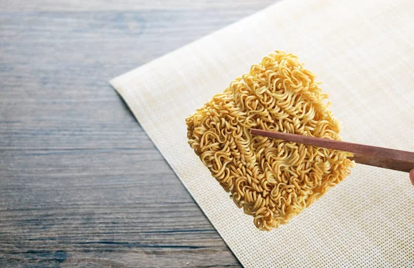 chopsticks and instant noodle on the wooden tabl