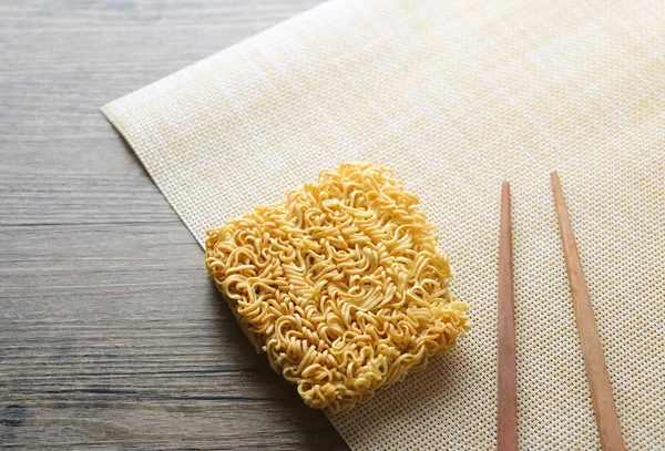 chopsticks and instant noodle on the wooden tabl