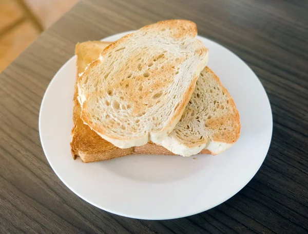 Två Skivor Toast Bröd Den Vita Plattan Träbord — Stockfoto