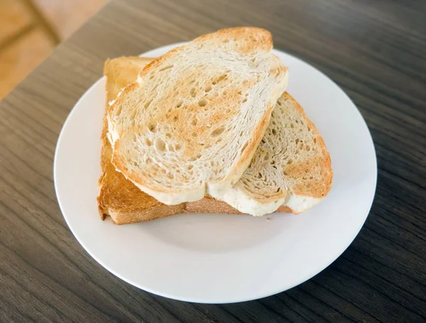 Dos Rebanadas Pan Tostado Plato Blanco Mesa Madera — Foto de Stock