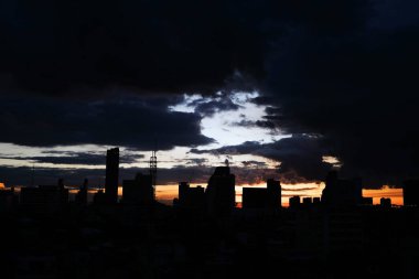 Bulutlar günbatımı ile şehrin üzerinde sk