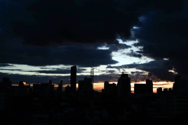 Bulutlar günbatımı ile şehrin üzerinde sk