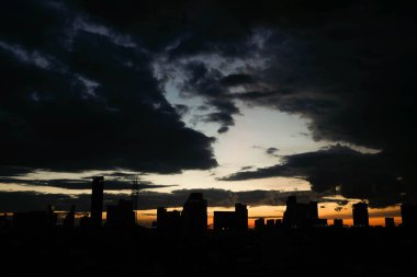 Bulutlar günbatımı ile şehrin üzerinde sk